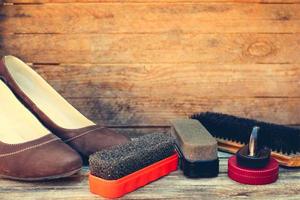 Women's shoes and care products for footwear on wooden background. photo