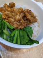 Close up photo of steam Kwetiau traditional noodle from Chinese with topping vegetables and chicken. The photo is suitable to use for traditional food background, poster and food content.