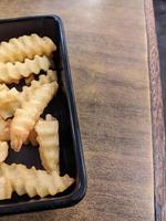 Close up fried fries with wooden table on the restaurant. The photo is suitable to use for traditional food background, poster and food content.