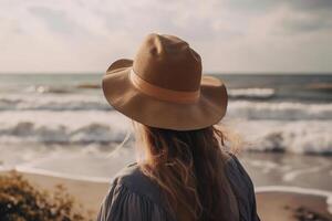 espalda ver imagen de un joven mujer en un sombrero en un mar costa. generado ai. foto