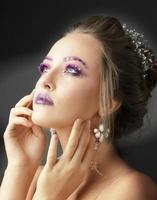 Model girl with bright makeup. Fashion makeup. Woman with violet restresses and eyebrows. Beautiful young face. photo