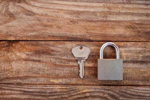 key and lock on wooden background. Toned image. photo