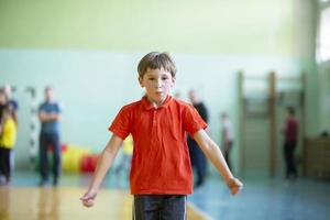 chico a un físico educación lección en un gimnasio foto