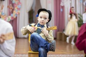 ruso chico con un balalaica. gracioso preescolar con ruso gente musical instrumento. foto