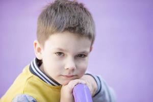 .seis año antiguo chico. primario colegio alumno. preescolar niño en un púrpura antecedentes. foto