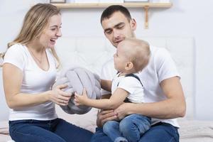 mamá, papá y pequeño hijo son jugando a hogar. joven familia con un niño. foto