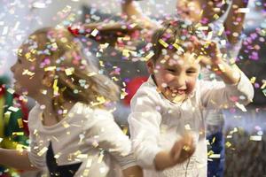 Background party for children. Multicolored confetti on the background of joyful faces. photo