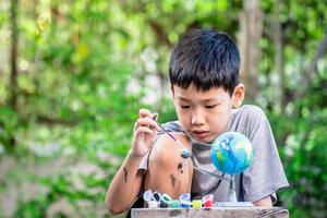 Concentrated asian boy coloring solar system toys, sensory activity, learning tools at home. photo