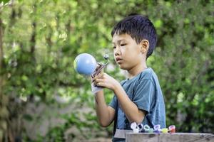 Concentrated asian boy coloring solar system toys, sensory activity, learning tools at home. photo