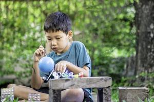 Concentrated asian boy coloring solar system toys, sensory activity, learning tools at home. photo