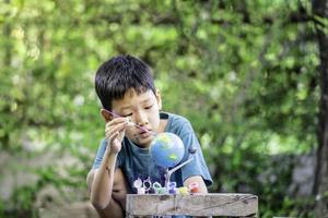 Concentrated asian boy coloring solar system toys, sensory activity, learning tools at home. photo