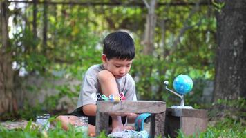konzentriert asiatisch Junge Färbung Solar- System Spielzeuge, sensorisch Aktivität, Lernen Werkzeuge beim heim. video