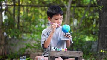geconcentreerd Aziatisch jongen kleur zonne- systeem speelgoed, zintuiglijk werkzaamheid, aan het leren gereedschap Bij huis. video