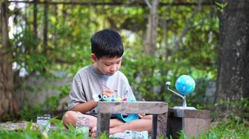 concentrato asiatico ragazzo colorazione solare sistema giocattoli, sensoriale attività, apprendimento utensili a casa. video