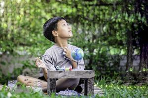 Concentrated asian boy coloring solar system toys, sensory activity, learning tools at home. photo