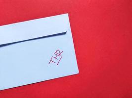 Top view of white envelope that says THR isolated on a red background photo