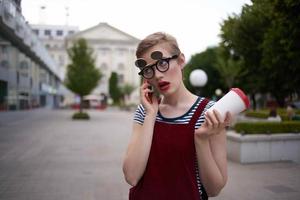 corto peludo mujer vistiendo lentes caminar vaso con bebida descanso foto