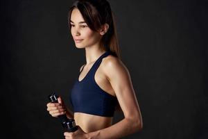 sporty woman in black top with dumbbells in hands cropped view of workout exercise photo