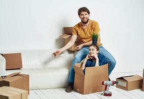 hombre y mujer en un nuevo Departamento cajas con cosas interior foto