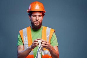 hombre en construcción uniforme naranja casco la seguridad emociones azul antecedentes foto
