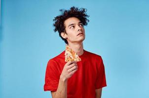 guy where is he and hair in a red t-shirt with a slice of pizza on a blue background photo