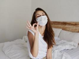 woman in medical mask shows hand gesture positive photo