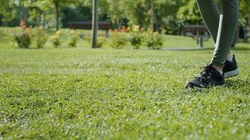 Closeup woman hands rolling up yoga mat on the grass in park. video