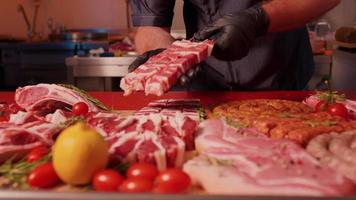 Man placing barbeque preps of square raw meat on skewers. video