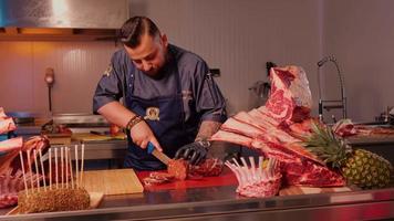 macellaio affettare fatto a mano salsiccia nel un' macellai cucina. video