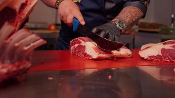 Butcher hands gently cutting raw fresh beef meat ribeye steak. video