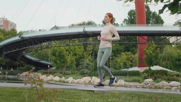 kvinna framställning kort ha sönder till andetag medan löpning. video