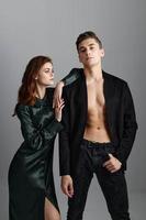 Sexy guy and fashionable woman on gray background stand side by side cropped view photo