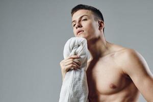 sport guy with towel wipes sweat workout isolated background photo