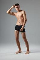 sporty man in black shorts posing on isolated background photo