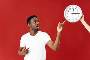 man in white t-shirt shows finger at watch isolated background photo