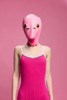 muy extraño mujer en un rosado silicona pescado máscara para Víspera de Todos los Santos, loco imagen en rosado ropa foto