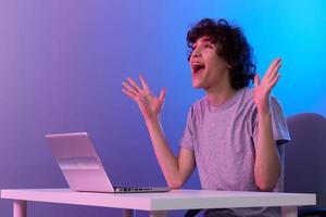 curly guy cyberspace playing with headphones in front of a laptop isolated background photo