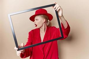 mujer marco en mano en rojo sombrero y chaqueta estudio modelo inalterado foto