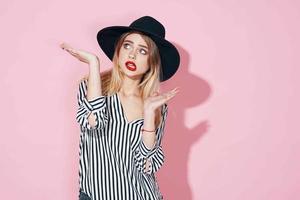 elegant woman in black hat red lips fashion posing pink background photo