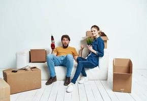 family young couple on the couch fun moving boxes with things photo