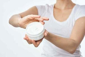 woman shows a jar of cream cosmetology hand lotion health photo