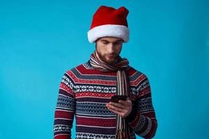 Cheerful man in a Santa hat with a phone in his hands isolated background photo