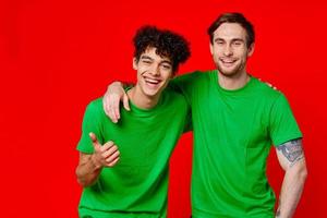 alegre amigos en verde camisetas abrazos comunicación positivo foto