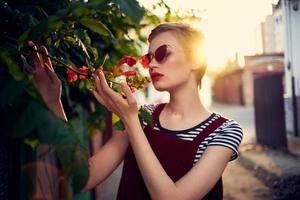 woman in sunglasses on the street near flowers posing lifestyle photo