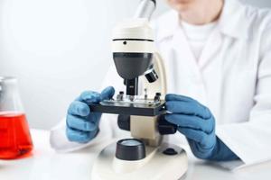 woman scientist looking through a microscope laboratory research diagnostics photo