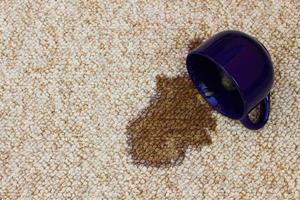 Coffee spilled from the cup on the carpet photo