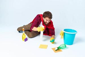 cleaner with cleaning supplies in a red raincoat on the floor of the house interior photo