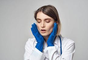 médico en azul médico guantes gesticulando con su manos en un gris antecedentes recortado ver foto