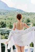 attractive young woman in lingerie on the balcony beautiful view from the window Relaxation concept photo