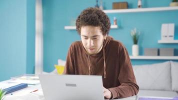 jovem aluna homem estudando às casa e desfrutando Boa notícia em computador portátil. Deleitado estudante. video